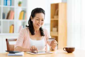 Mujer comprando online con tarjeta de credito usando una tablet