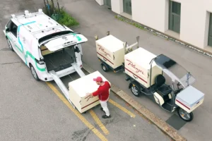 Hombre cargando con productos un vehículo autónomo de LOXO