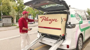 Hombre cargando con productos un vehículo autónomo de LOXO